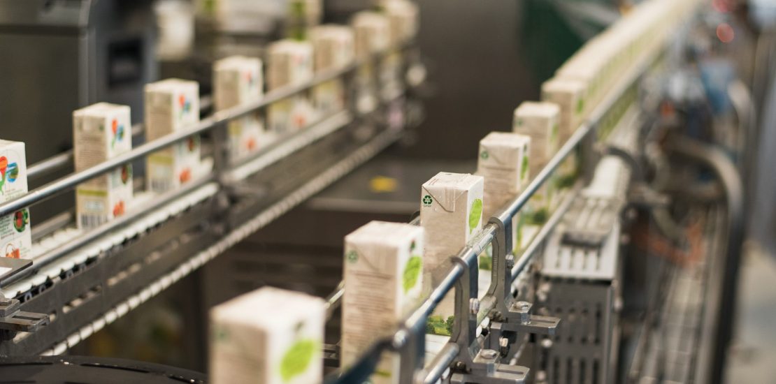 Conveyor at the plant for the production and bottling of juices in cardboard packaging.